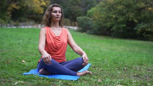 Chica haciendo yoga en el parque en otoño 4k — Vídeos de Stock