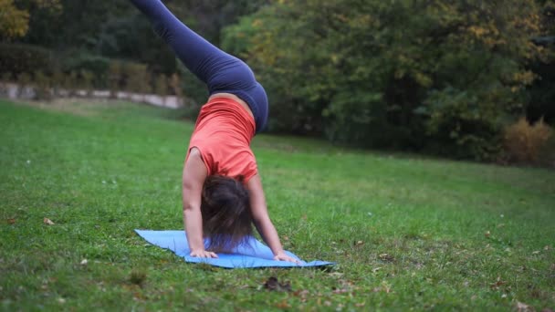 Chica haciendo yoga en el parque en otoño 4k — Vídeos de Stock