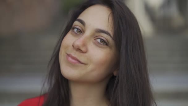 Pequeña chica posando en la cámara. Retrato cerrado de una joven guapa con ojos verdes — Vídeo de stock