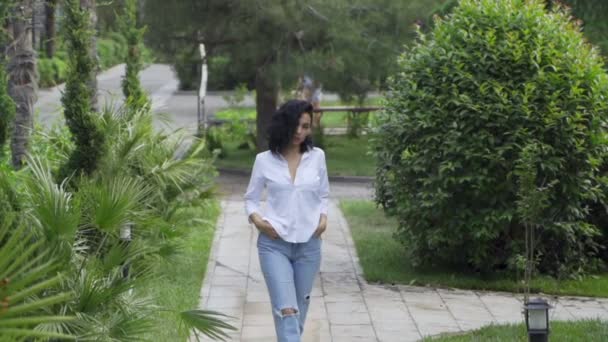 Красива Татарська дівчина в парку ходить по тротуару — стокове відео