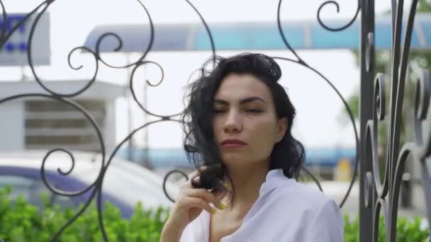 Красивая татарская девушка стоит возле металлической беседки — стоковое видео
