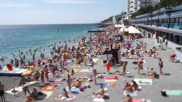 Stranden på sommaren är full av solbadare och simning i havet. Båtar och båtar flyter i havet 4K — Stockvideo