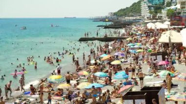 Yaz aylarında plaj bir sürü insan yüzmek ve denizde eğlenmek, tekneler ve tekneler Yalta 4k zaman atlamalı yelken