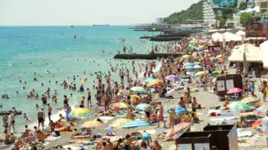Yaz aylarında plaj bir sürü insan yüzmek ve denizde eğlenmek, tekneler ve tekneler Yalta 4k yelken