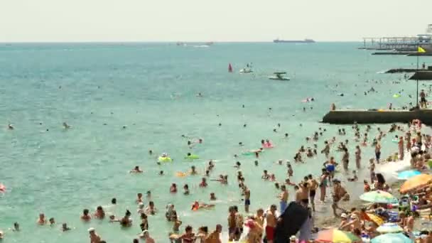 夏天的海滩有很多人在海里游泳和玩乐，船和船在雅尔塔航行4k时差 — 图库视频影像