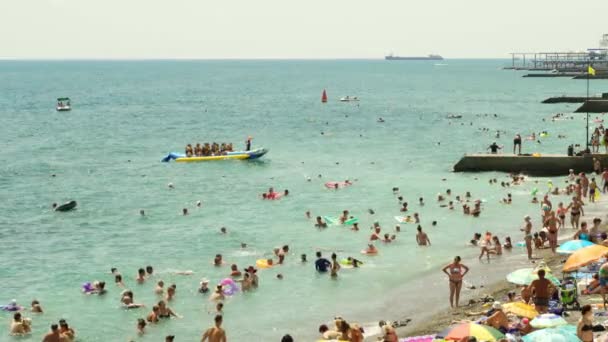 夏天的海滩很多人在海里游泳和玩乐，船和船在雅尔塔航行4k — 图库视频影像