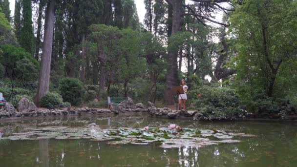 Künstlerin im Park malt eine Landschaft mit Ölfarben einen kleinen alten Teich 4k — Stockvideo