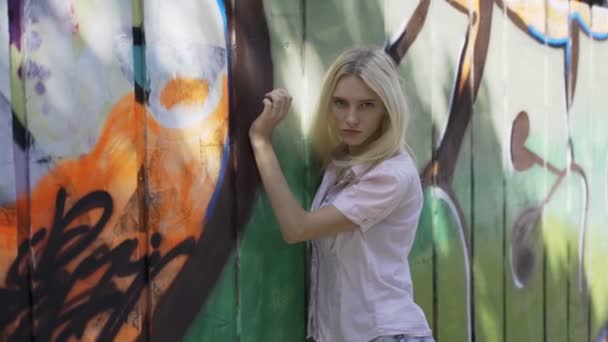 Chica Rubia Joven Posando Sobre Fondo Una Pared Con Grafitti — Vídeos de Stock