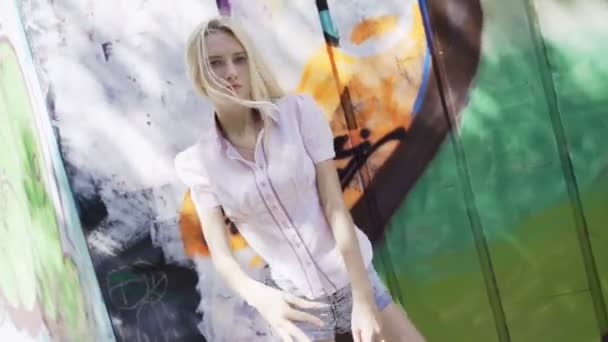 Chica Rubia Joven Posando Sobre Fondo Una Pared Con Grafitti — Vídeos de Stock