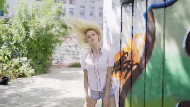 Jonge Blonde Meisje Poseren Tegen Een Achtergrond Van Een Muur — Stockvideo