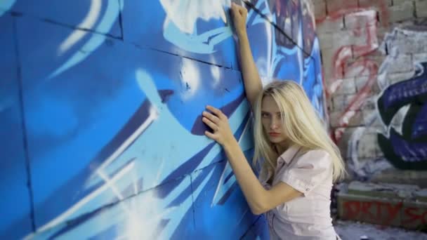 Menina Loira Posando Contra Fundo Uma Parede Com Grafitti Sessão — Vídeo de Stock