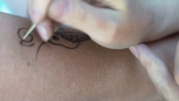 Het meisje op de onderarm is gemaakt met henna tattoo. — Stockvideo