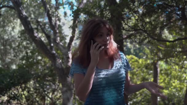 공원에서 소녀가 전화로 이야기하고 누군가와 말다툼을하고 있습니다 즐거운 통화가 아닙니다 — 비디오