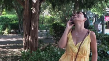 Güzel kız sevinçle bir cep telefonu konuşuyor