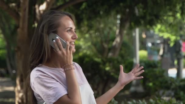 Красивая девушка с радостью разговаривает по мобильному телефону — стоковое видео