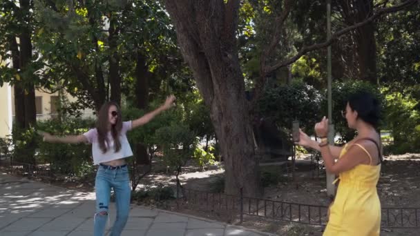 Twee meisjes schieten elkaar op een mobiele telefoon. — Stockvideo