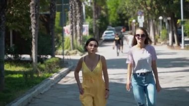 İki genç kız sevinçle yol boyunca koşmak