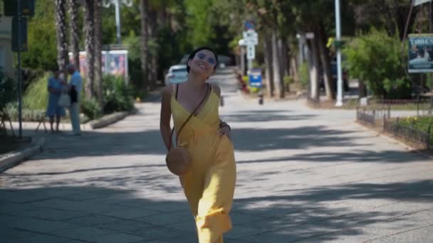 Chica joven corre alegremente a lo largo de la carretera — Vídeos de Stock