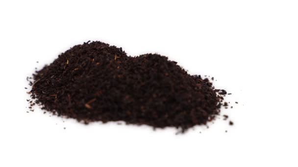 Garstka czarnych liści herbaty obraca się na białym tle. 4k — Wideo stockowe