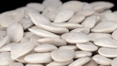 Siyah arka planda kabak çekirdeği kabuğu soymak değil. Balkabağı çekirdekleri 360 derece döner. 4k