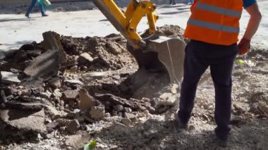 Yol inşaatında kürekle asfalt yolda çalışan bir inşaat işçisi. Yol kavramı işe yarar. 4k