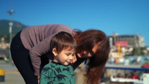 Eine junge Mutter und ihr Sohn laufen durch die Stadt — Stockvideo