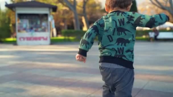 Two year old son runs to mom in the city — Stock Video