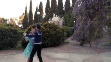 Genç bir adam ve bir kız vals yapıyorlar. Bir öğrenci ve mavi elbiseli bir kız eski bir parkta dans ediyorlar. 4k