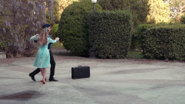 一个年轻人和一个女孩在跳华尔兹 一个学员和一个穿蓝色衣服的女孩在一个老公园里跳舞 — 图库视频影像