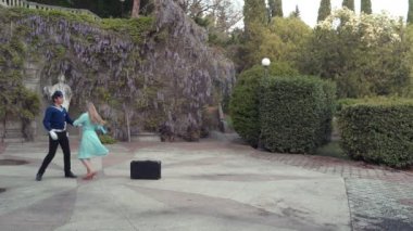 Genç bir adam ve bir kız vals yapıyorlar. Bir öğrenci ve mavi elbiseli bir kız eski bir parkta dans ediyorlar. 4k