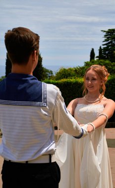 Dans eden genç çift pozu. Bir denizci üniformalı bir adam ve güzel elbiseli bir kız..