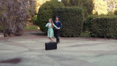 Genç bir adam ve bir kız vals yapıyorlar. Bir öğrenci ve mavi elbiseli bir kız eski bir parkta dans ediyorlar. 4k