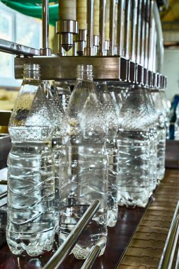 Saf içme suyu bitkisi. Girişimcilik için nakliyeci. Taşıyıcıdaki limon şişeleri suyla dolu.