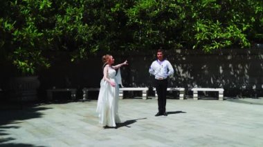 Genç bir adam ve bir kız vals yapıyorlar. Bir öğrenci ve beyaz balo elbisesi giymiş bir kız parkta dans ediyorlar. Yavaş çekimde vals dansı.