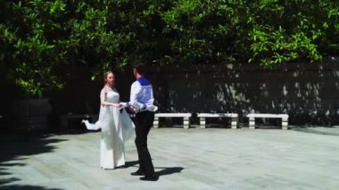 Genç bir adam ve bir kız vals yapıyorlar. Bir öğrenci ve beyaz balo elbisesi giymiş bir kız parkta dans ediyorlar. Yavaş çekimde vals dansı.
