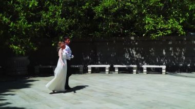 Genç bir adam ve bir kız vals yapıyorlar. Bir öğrenci ve beyaz balo elbisesi giymiş bir kız parkta dans ediyorlar. Yavaş çekimde vals dansı.