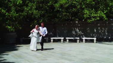 Genç bir adam ve bir kız vals yapıyorlar. Bir öğrenci ve beyaz balo elbisesi giymiş bir kız parkta dans ediyorlar. Yavaş çekimde vals dansı.