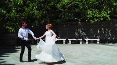 Genç bir adam ve bir kız vals yapıyorlar. Bir öğrenci ve beyaz balo elbisesi giymiş bir kız parkta dans ediyorlar. Yavaş çekimde vals dansı.