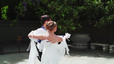 Genç bir adam ve bir kız vals yapıyorlar. Bir öğrenci ve beyaz balo elbisesi giymiş bir kız parkta dans ediyorlar. Yavaş çekimde vals dansı.