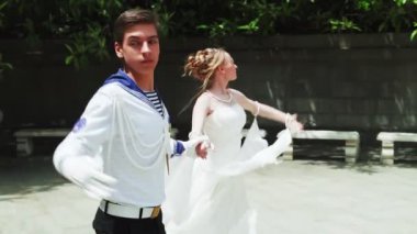 Genç bir adam ve bir kız vals yapıyorlar. Bir öğrenci ve beyaz balo elbisesi giymiş bir kız parkta dans ediyorlar. Yavaş çekimde vals dansı.