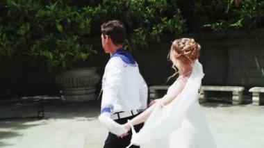 Genç bir adam ve bir kız vals yapıyorlar. Bir öğrenci ve beyaz balo elbisesi giymiş bir kız parkta dans ediyorlar. Yavaş çekimde vals dansı.