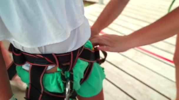 孩子们在缆绳公园 指导员给一个小女孩配备了在缆绳公园进行户外活动的设备 — 图库视频影像