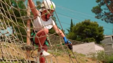 Çocuklar halat parkında. İki kız kardeş bir halat parkında engelli bir pistte yürür ve birbirlerine beş dakika verirler. 4k