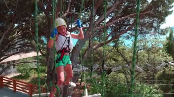 Des enfants dans le parc à cordes. Les petites filles ont un parcours d'obstacles dans un parc à cordes. 4k