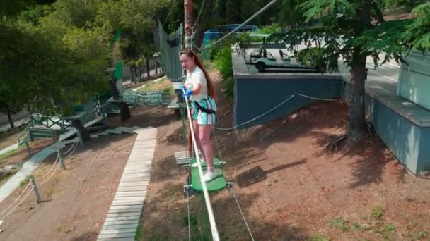 Crianças no parque das cordas. Adolescente menina corre um curso de obstáculo em um parque de corda . — Vídeo de Stock