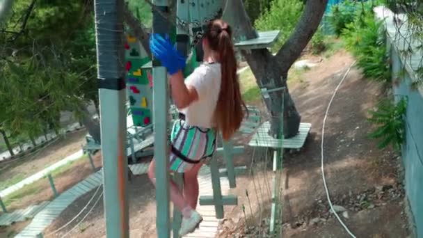 Niños en el parque de cuerdas. Adolescente chica corre una carrera de obstáculos en un parque de cuerdas . — Vídeo de stock