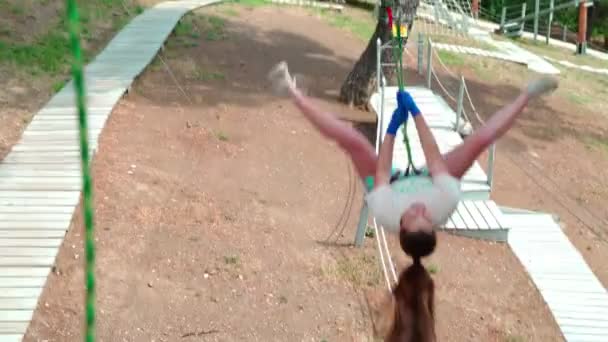 Niños en el parque de cuerdas. Adolescente chica corre una carrera de obstáculos en un parque de cuerdas . — Vídeo de stock