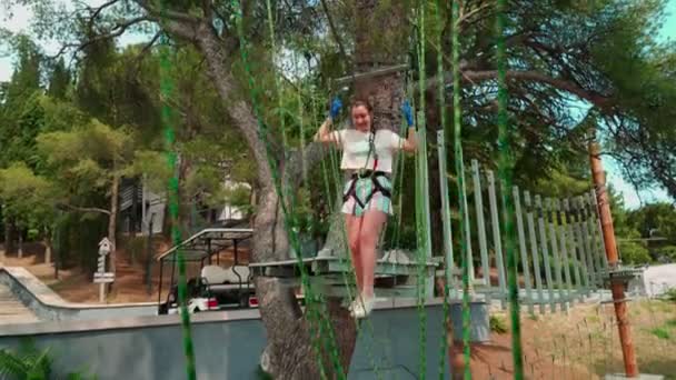 Children in the rope park. Teenager girl runs an obstacle course in a rope park. — Stock Video