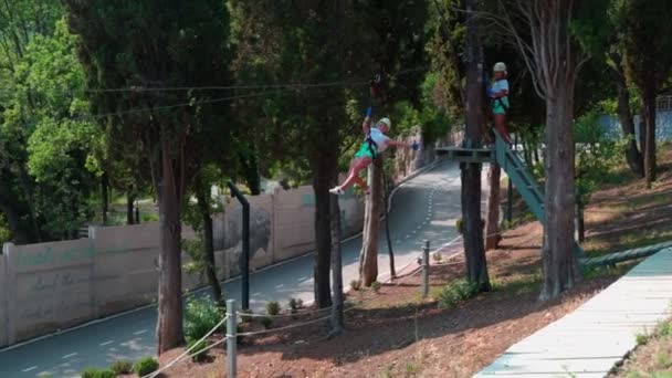 Niños en el parque de cuerdas. Una niña pequeña en un parque de cuerdas con una velocidad se tira de un bungee . — Vídeo de stock