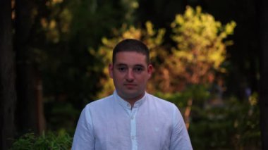 Parktaki ağaçların arka planında bir adamın portresi..